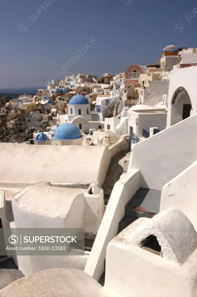 Greece, Cyclades, Santorini, View Over White Town Architecture With Occasional Blue Domes