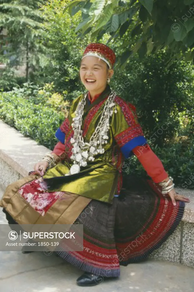China, Guizhou, Kiali, Seated Miao Girl  Wearing Festival Dress