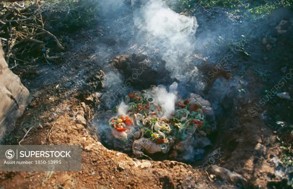 Libya, Cyranaica, Cooking Meat On Hot Stones In A Hole In The Ground.