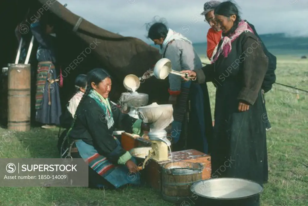 Tibet, People, Tibetan Nomad Women On The High Grasslands With Cream Seperator Brought By Travelling Salesman.