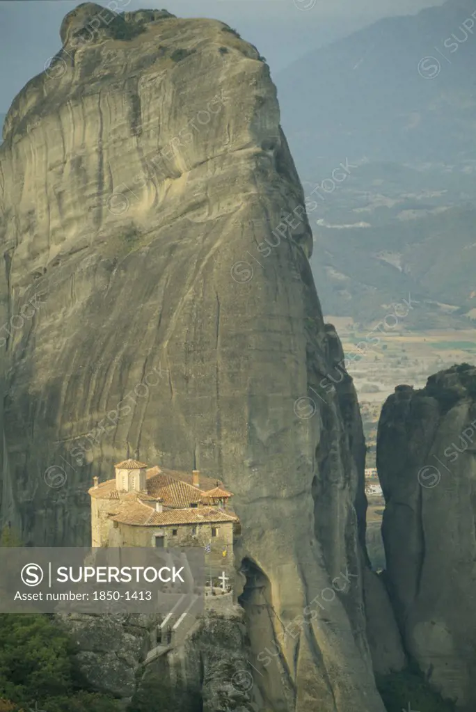 Greece, Central Greece, Meteora, Roussanou Monastery With Large Rock Formation Behind.