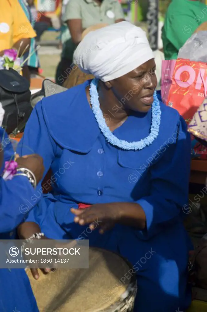 West Indies, St Vincent & The Grenadines, Union Island, Woman Playing A Drum Amongst The Baptist Congregation In Clifton At Easter Morning Harbourside Service For Those Lost At Sea