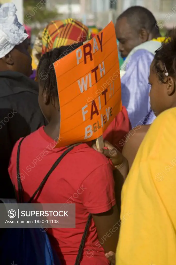 West Indies, St Vincent & The Grenadines, Union Island, Woman Carrying A Religious Placard Amongst The Baptist Congregation In Clifton At Easter Morning Harbourside Service For Those Lost At Sea