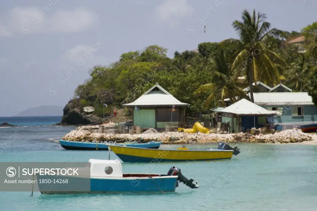 West Indies, St Vincent & The Grenadines, Mustique, Fishing Boats And Beachside Houses In Britannia Bay