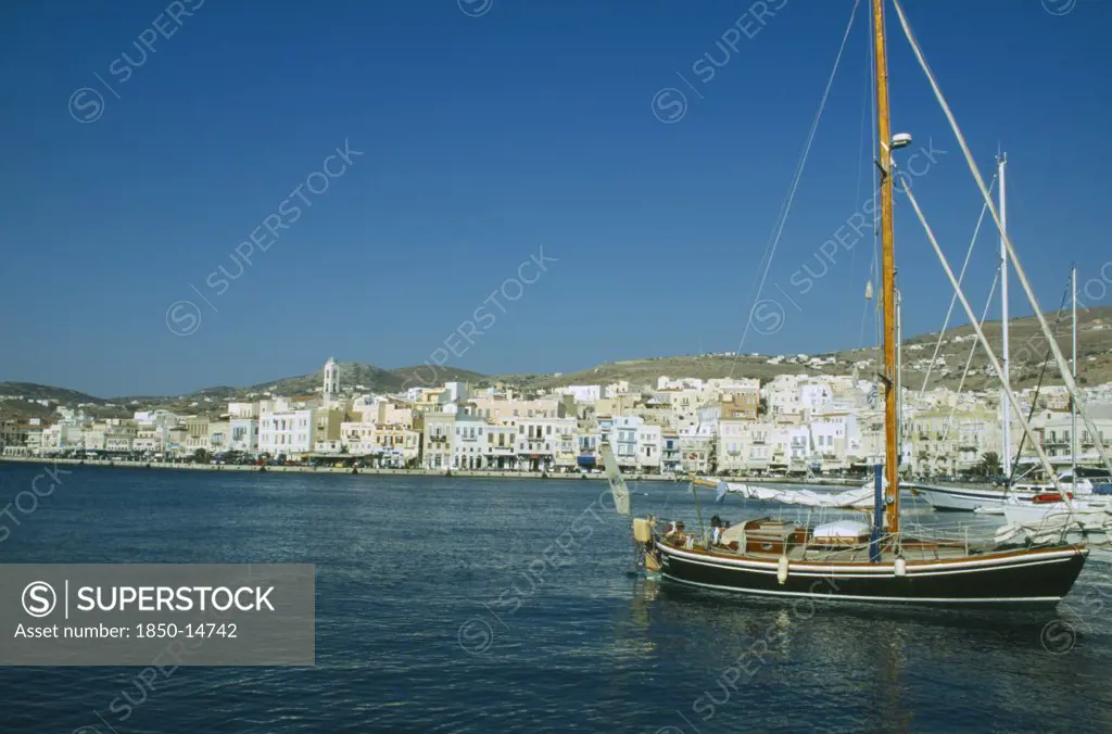 Greece, Cyclades Islands, Syros, Ermoupolis. Sailing Boats In The Port With View Of The Seaside Town.