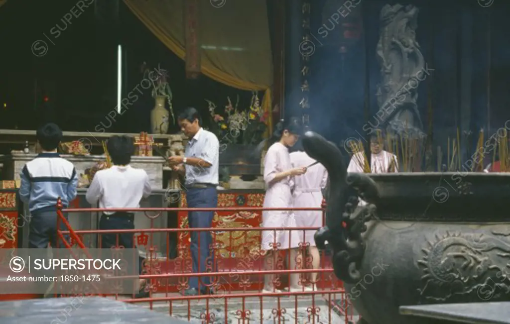 Taiwan, Tainan, People Making Offerings Of Incense At Temple.