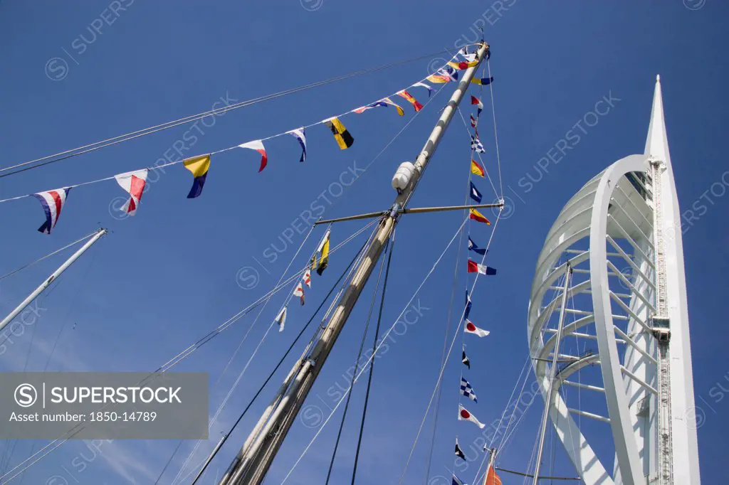 England, Hampshire, Portsmouth, The Spinnaker Tower The Tallest Public Viewing Platforn In The Uk At 170 Metres On Gunwharf Quay With Flags Decorating A Yachts Rigging In The Foreground
