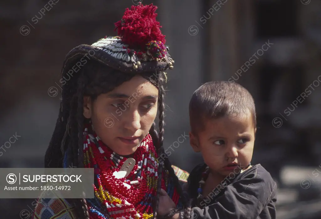 Pakistan, North West Frontier Province, Rumbur Valley, 'Mother Wearing Lots Of Colourful Beaded Necklaces, Holding Kalash Boy.'