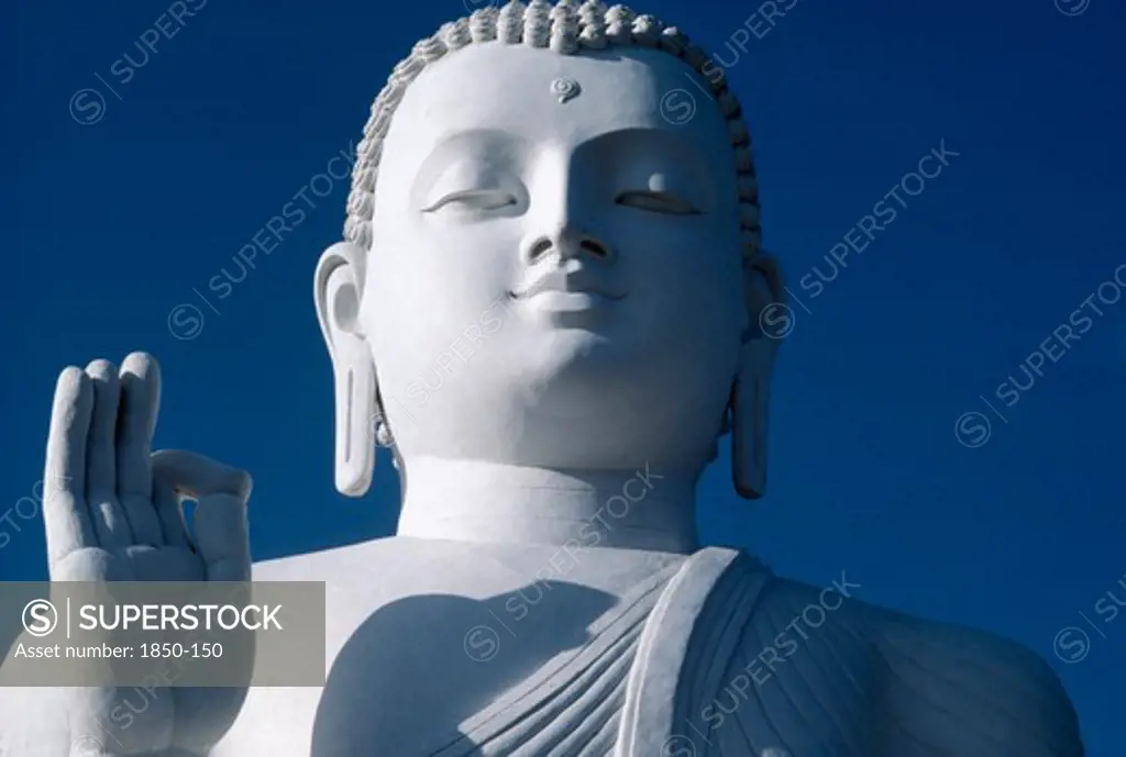 Sri Lanka, Mihinitale, White Buddha Statue Detail Of Head Shoulders And Hand Against Blue Sky