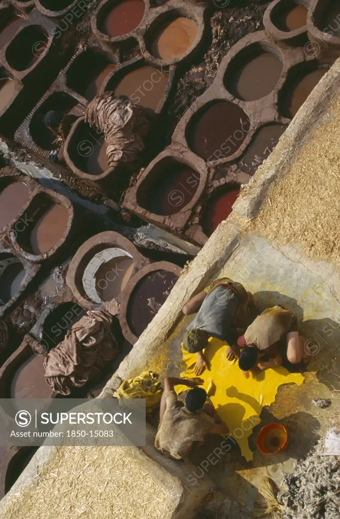 Morocco, Fes, Chouwara Tanneries.  Men Working At The TannerS Pits With Coloured Dyes.