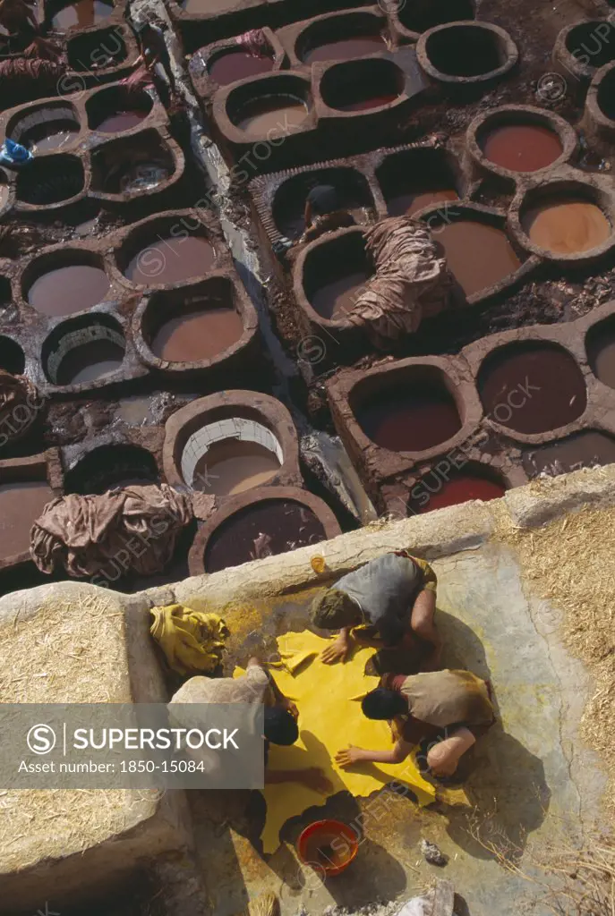 Morocco, Fes, Chouwara Tanneries.  Men Working At The TannerS Pits With Coloured Dyes.