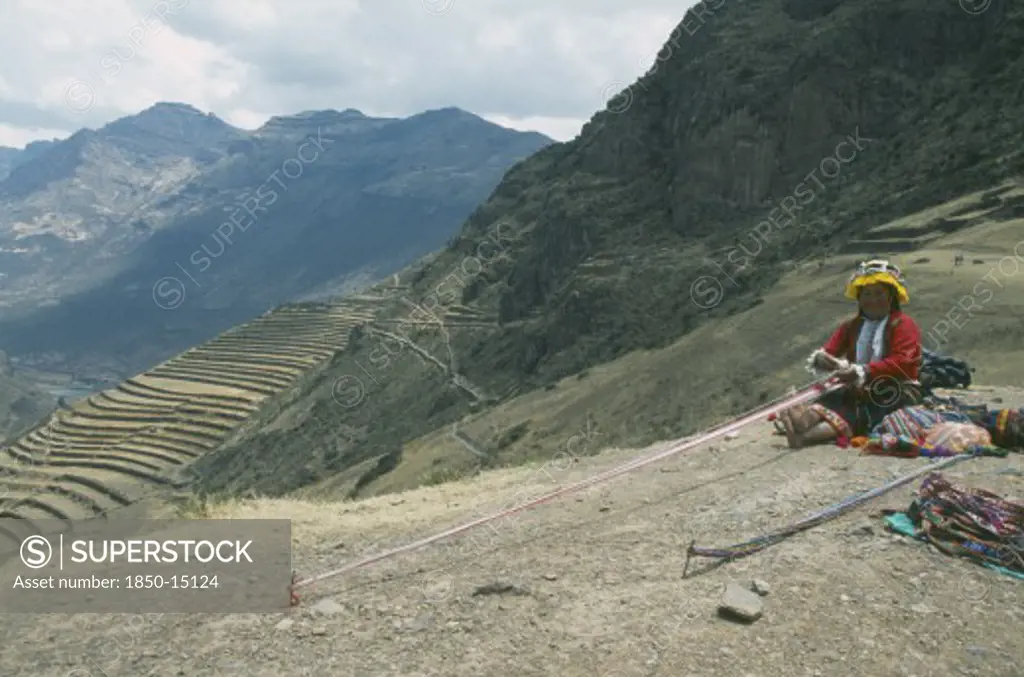 Peru, Cusco, Pisac, 'Quechuan Indian Woman Weaving, Inca Terracing Behind. Sacred Valley'