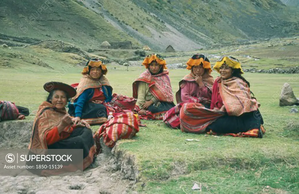 Peru, Cusco, Cancha Cancha, 'Local Quechuan Women Sat On Grass, Wearing Traditional Dress.'