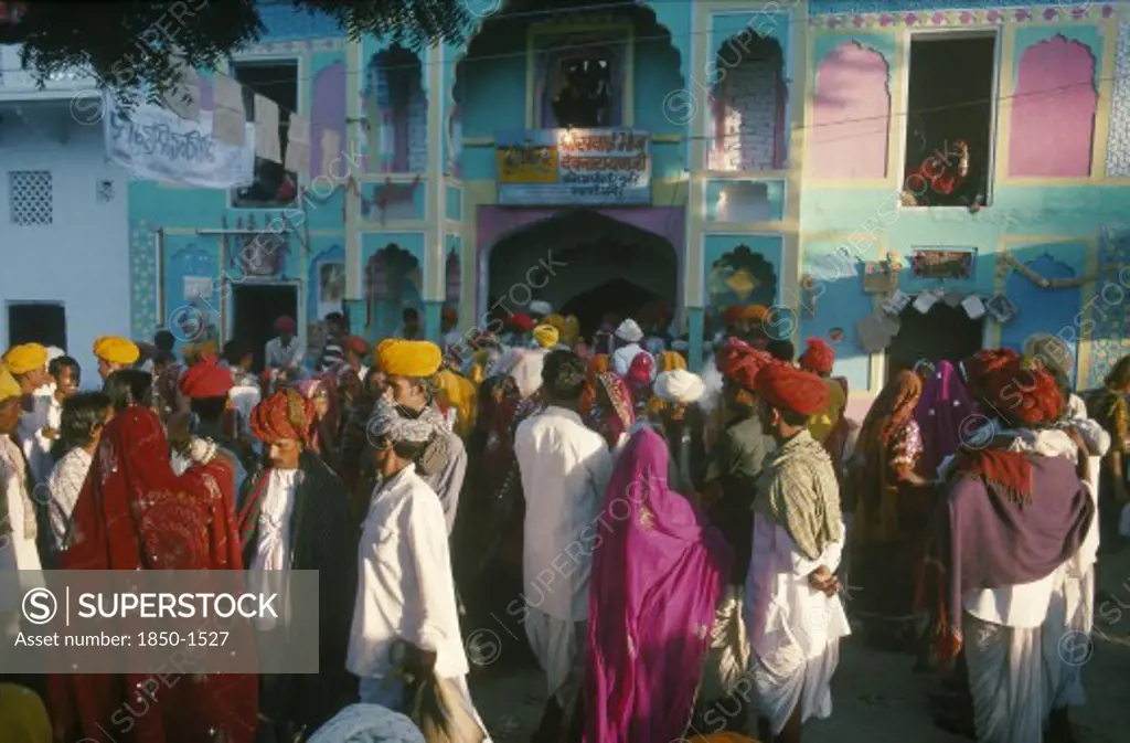 India, Rajasthan, Pushkar, A Crowded Street Of People Walking In Front Of Brightly Coloured Buildings During The Cattle Fair