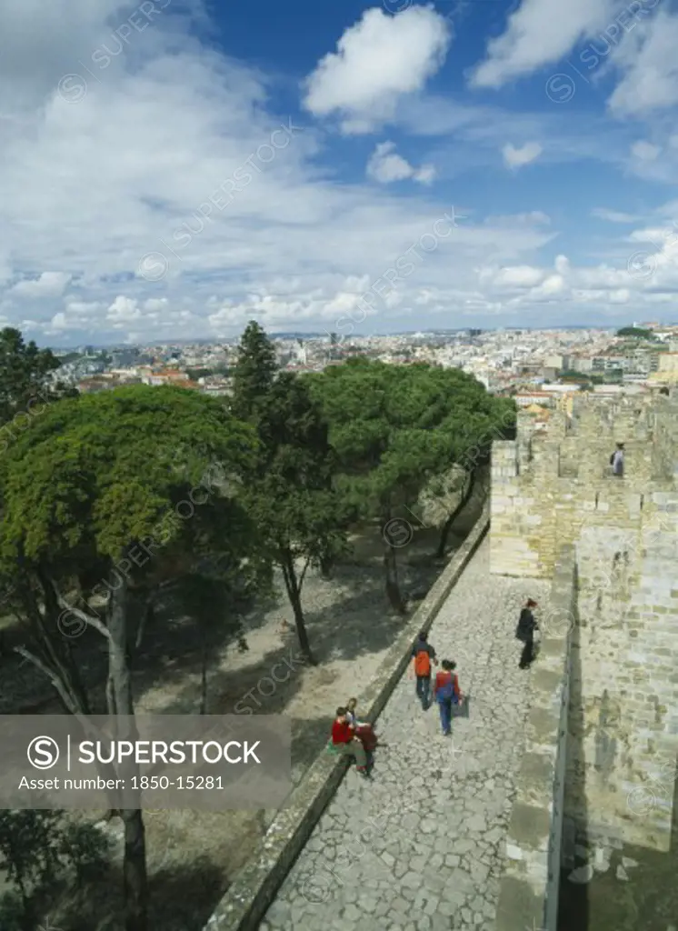 Portugal, Lisbon, Tourist Visitors On Fortified Walls Of Castelo De Sao Jorge  With City Stretched Out Beyond.
