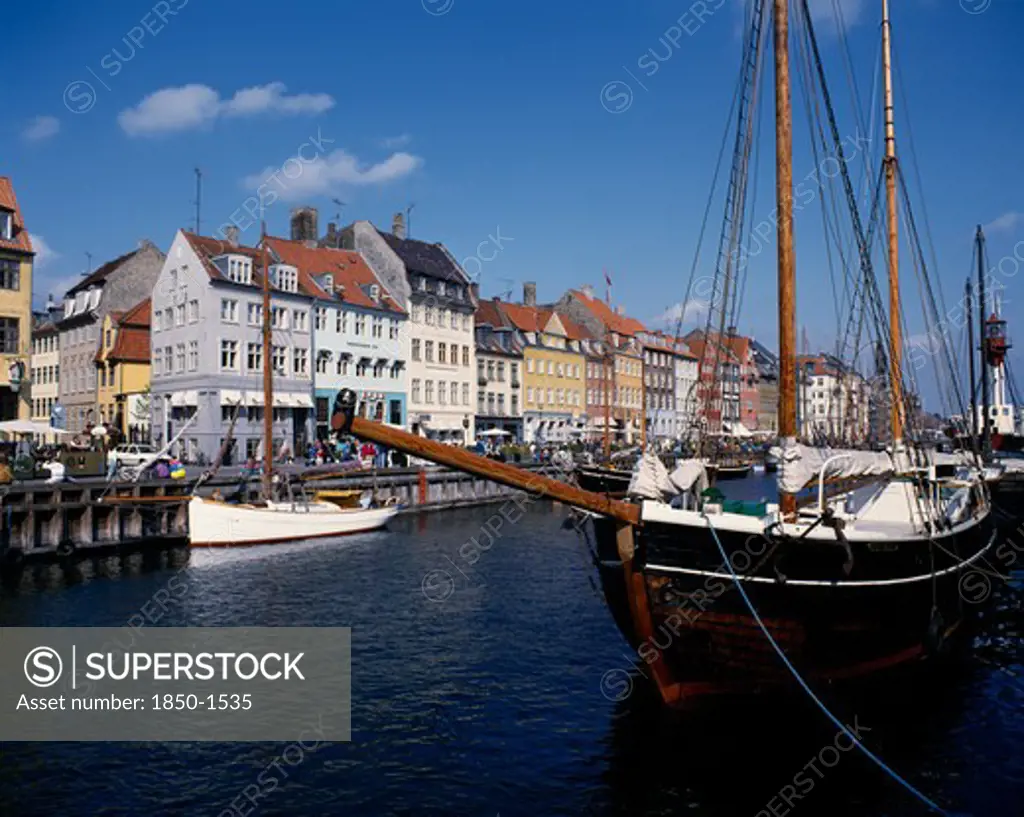 Denmark, Zealand, Copenhagen, Nyhavn Harbour. Traditional Waterfront Buildings With Moored Boats And A Schooner In The Foreground
