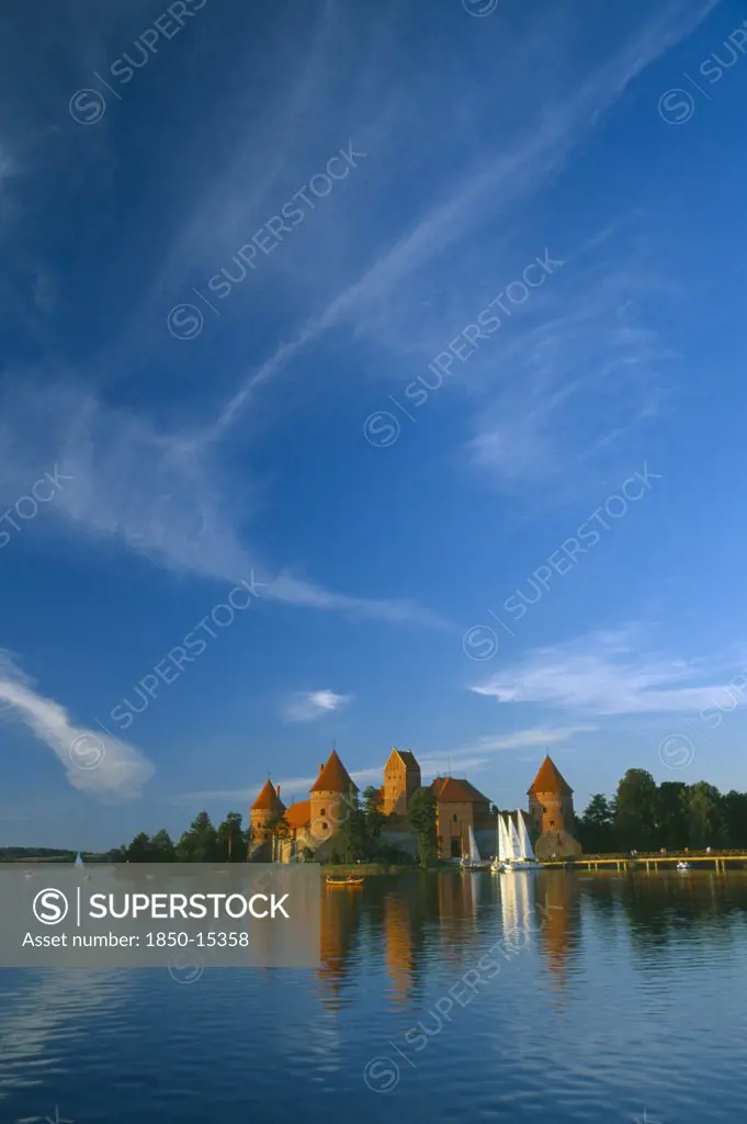 Lithuania, Trakai, 'Wide Angle View Of Castle Reflected In Lake With Windswept Clouds Above,'