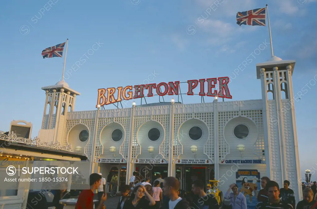 England, East Sussex, Brighton, Brighton Pier With Groups Of People In The Foreground.