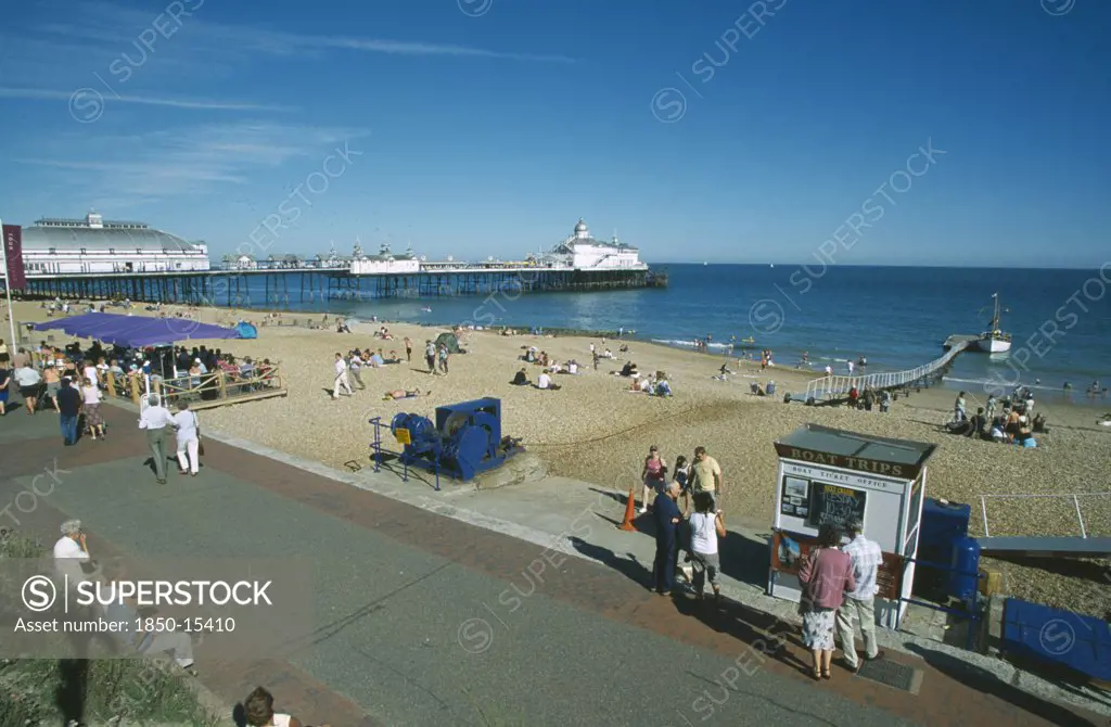 England, East Sussex, Eastbourne, View From Promenade Across Busy Beachfront And Pier.