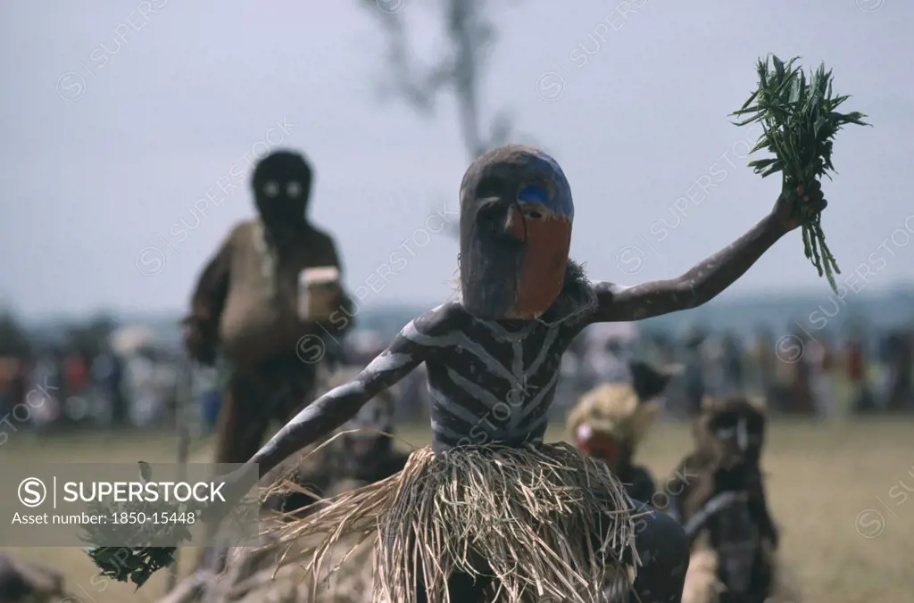 Congo, Gungu, Bapende Tribe Masked Dancer Wearing Grass Skirt And Body Paint At Gungu Festival.