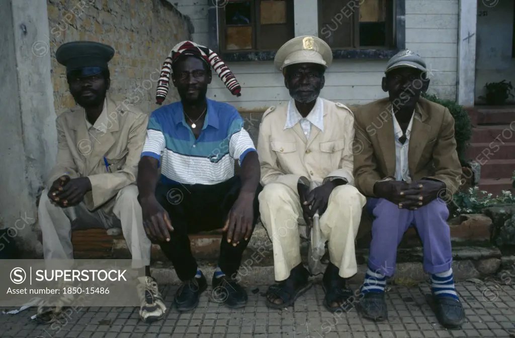 Angola, Malange, Four Malange Chiefs Seated And Wearing Different Hats.