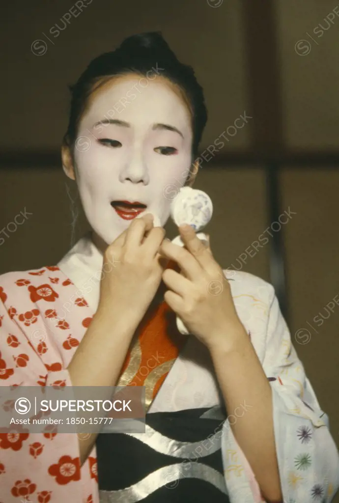 Japan, Honshu, Kyoto, Geisha Girl Applying Make Up.