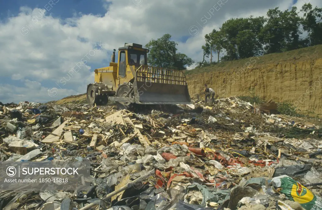 England, Surrey, Environment, Bulldozer On Heap Of Rubbish In Landfill Site.