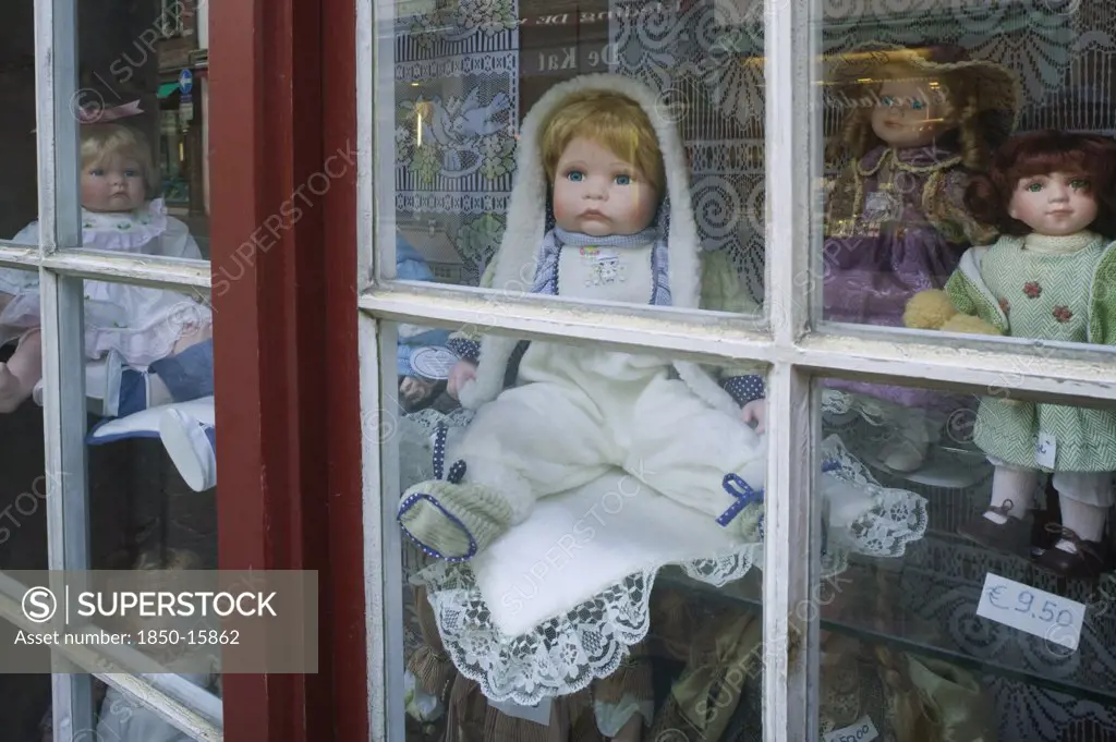 Belgium, West Flanders, Bruges, Assorted Porcelain Dolls In A Shop Window.