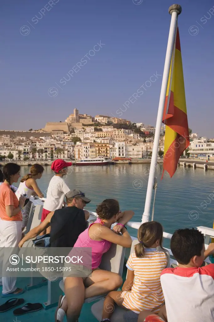 Spain, Balearic Islands, Ibiza, 'Passengers On Board A Ferry Leaving Eivissa For Formentera, Spanish Flag.'
