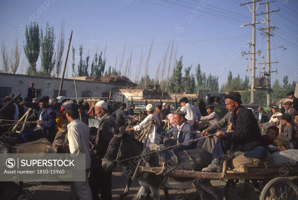 China, Xinjiang Province, Kashgar, Busy Street With Crowds Of Men Some Traveling On Donkey And Cart