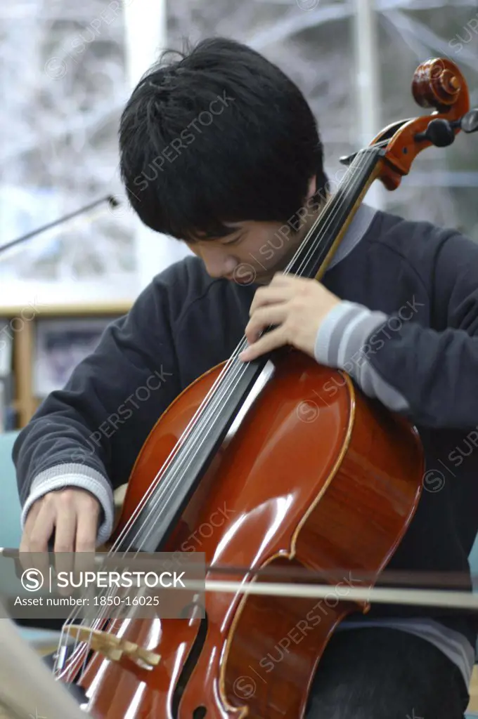 Japan, Chiba, Yokaichiba, Teenage Boy Playing Cello As Member Of United Freedom Orchestra