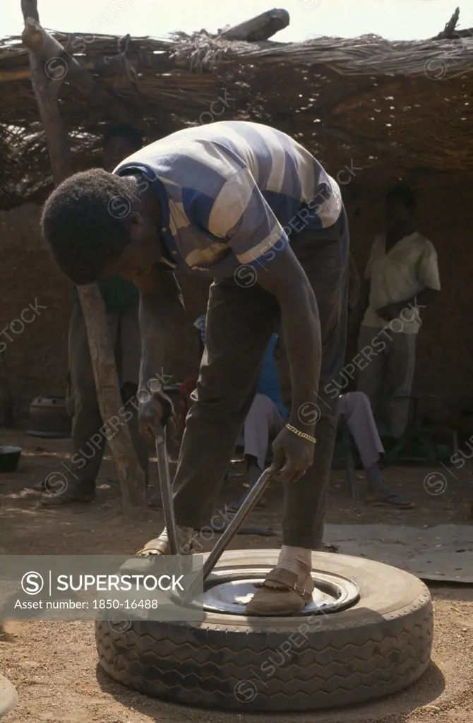 Ivory Coast, Transport, Man Mending Tyre Puncture