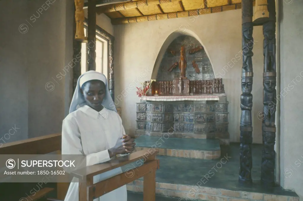 Zimbabwe, Serrisima Mission, Young Nun Praying In Front Of Altar Inside Mission.