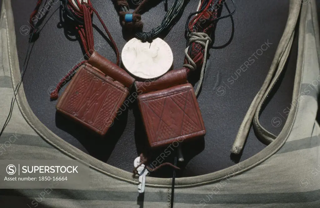 Sudan, Mornei Settlement, Close View Of Leather Pouches Containing Verses Of The Koran Worn Around The Neck As A Charm By Chadian Refugee Woman Together With Old French Coin And Beads.