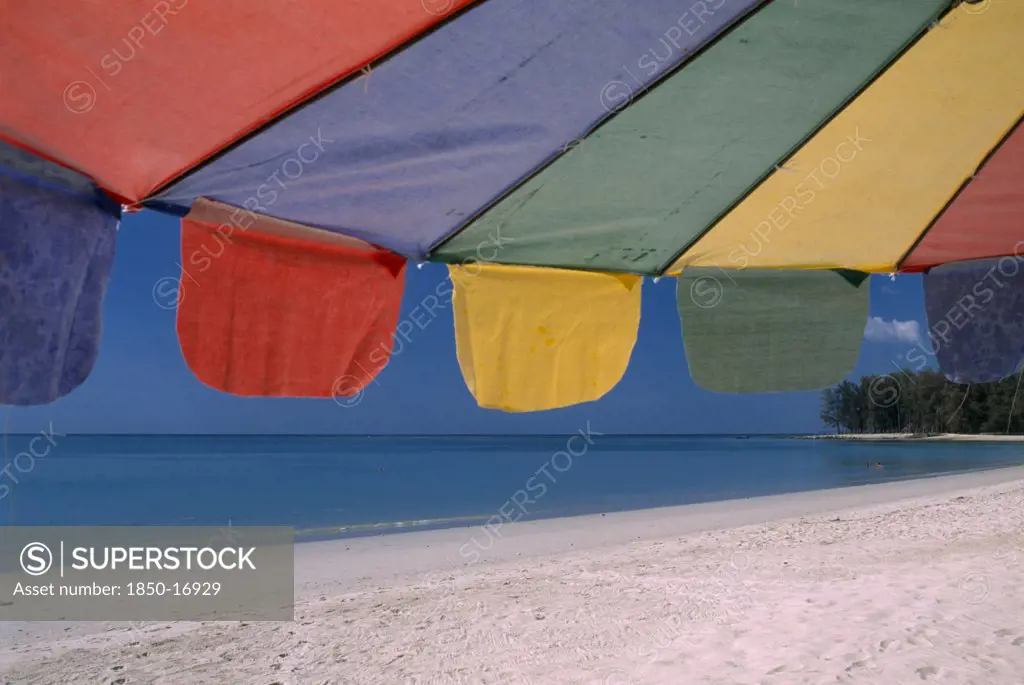Thailand, North Phuket, Naiyang Beach, Close Up Of A Multi Coloured Parasol On The Sandy Beach.
