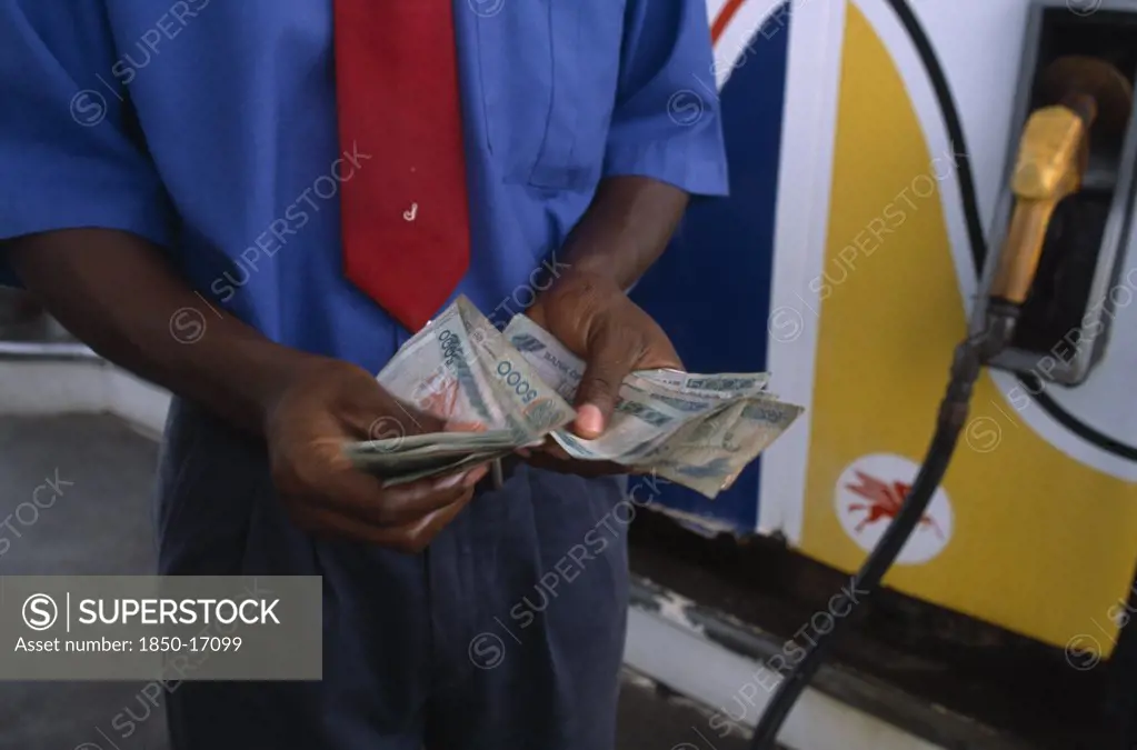 Ghana, Money, Ghanaian Currency.  Counting Cedi Bank Notes At A Petrol Station.