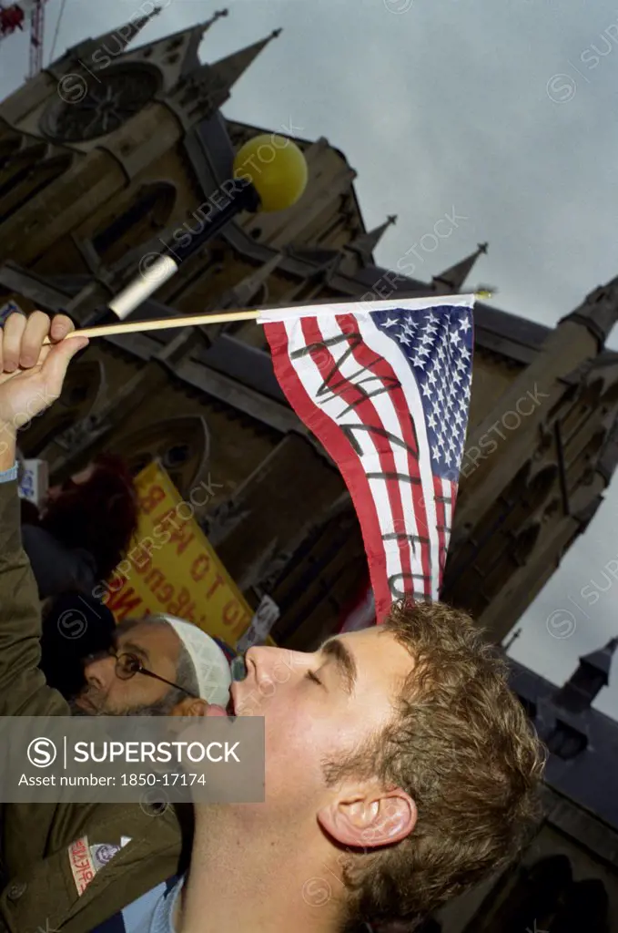 England, London, A Demonstrator Waves A Defaced North American Flag During An Anti Bush Rally.