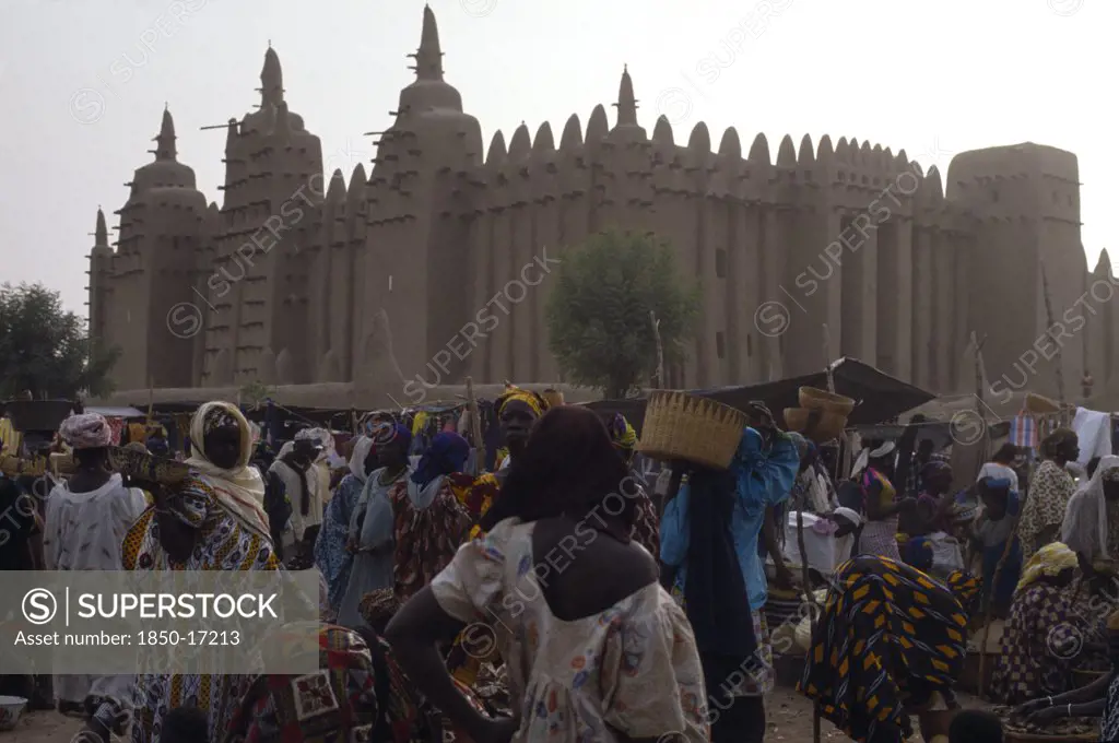 Mali, Sahel, Djenne, Busy Market Scene With Grand Mosque Behind.