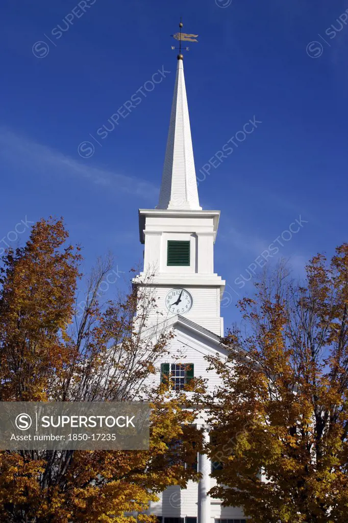 Usa, New Hampshire, Dublin, 'Close Up Of White Church With Clock On Spire And Tall Columns At Entrance,  Golden Leaves On Trees.'