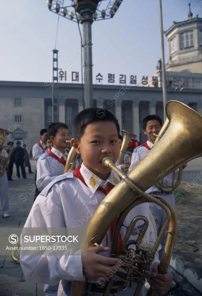 North Korea, North Hwanghhae Province, Pyongsan County, Boys In Juche Band Playing Brass Instruments Outside Railway Station