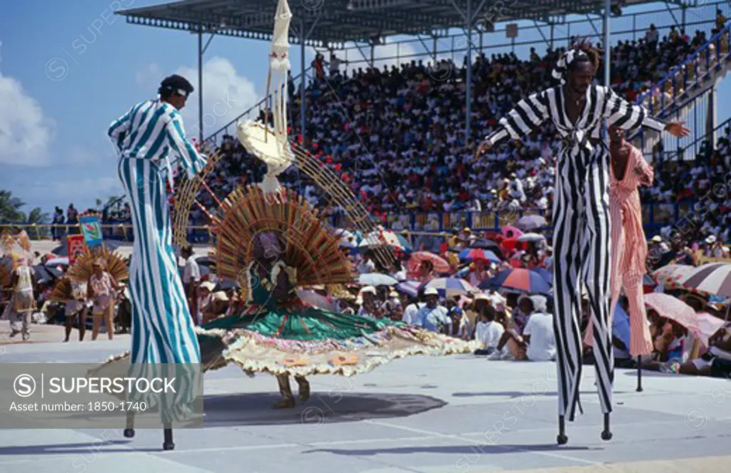 West Indies, Barbados, Festivals, Crop Over Sugar Cane Harvest Festival.  Grand Kadooment Carnival Parade Stilt Walkers In Striped Costume.