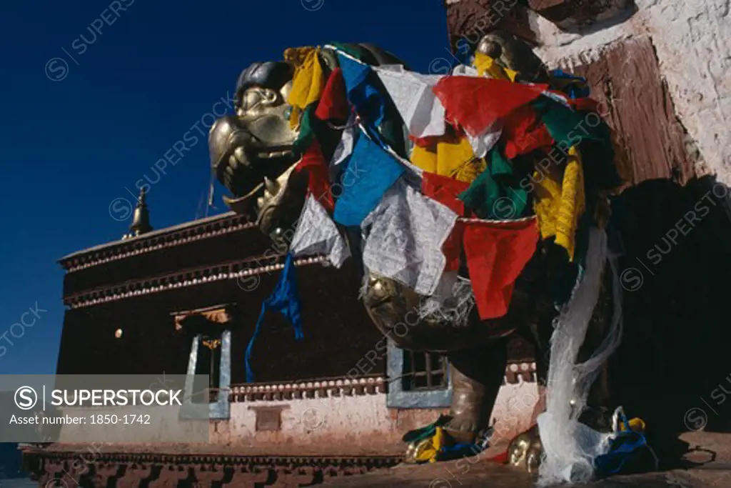 China, Tibet, Lhasa, Potala Palace Statue Covered In Prayer Flags