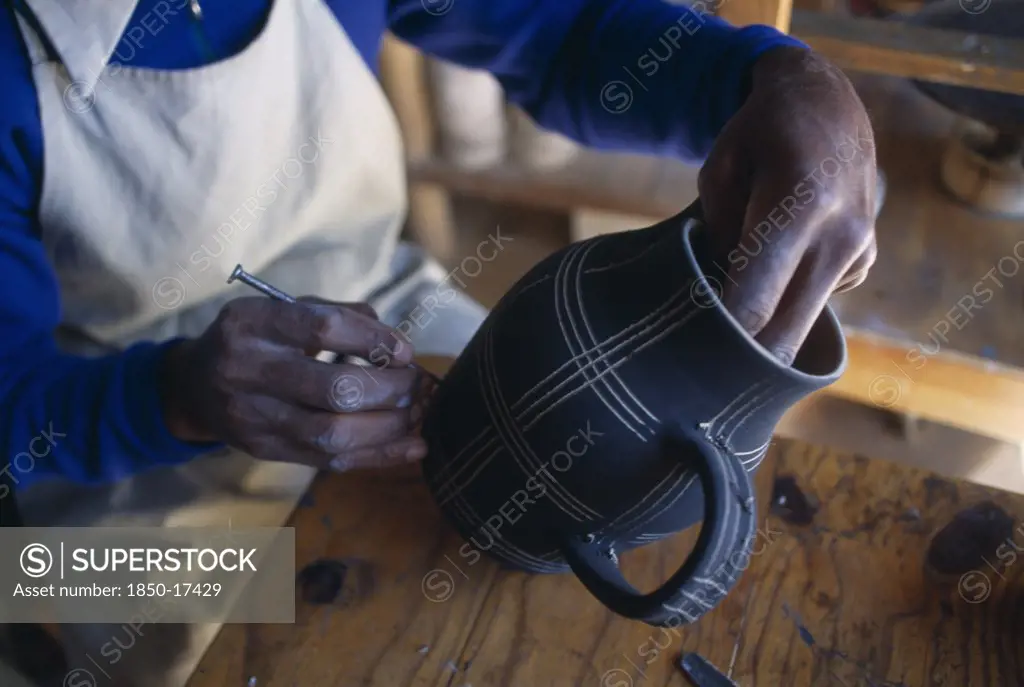 Malawi, Dedza, Dedza Potteries Producing Fair Trade Goods For Export.  Craftsman Decorating Pot.