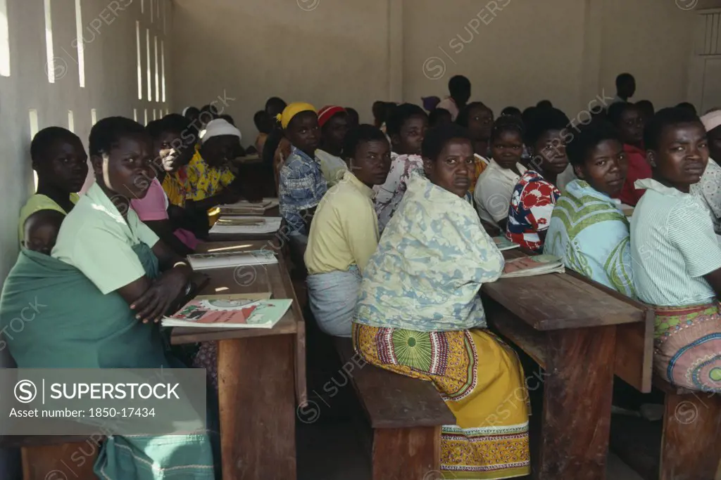 Malawi, Kunyinda Camp, Mozambican Refugee Women Attending Adult Literacy Class. Young Woman In Foreground With Child Asleep On Her Back.