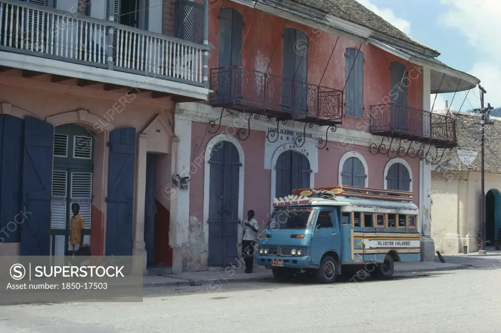 Haiti, Cap Haitien, Street Scene With Typical Colonial Style Architecture And Bus.