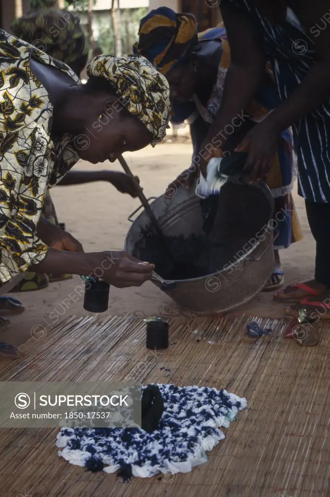 Gambia, Arts, Woman Applying Indigo Dye To Cloth During Tie Dye Process.