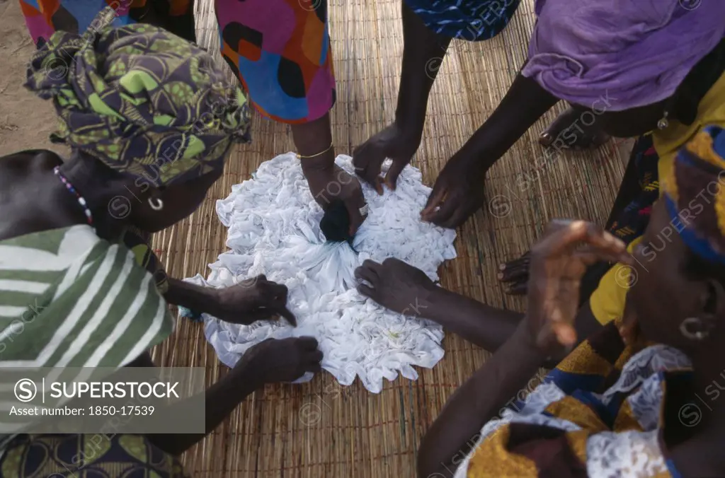 Gambia, Arts, Women Applying Indigo Dye To Cloth During Tie Dye Process.