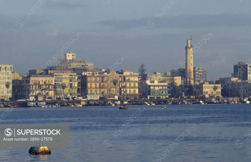 Egypt, Port Said, City On Coast Where The Suez Canal Meets The Mediterranean And Founded In 1859 To House Canal Workers.  City And Suez Canal At Dusk.