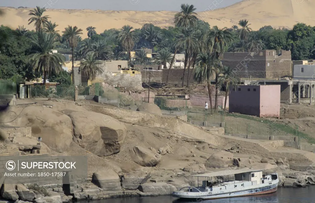 Egypt, Nile Valley, Elephantine Island, 'Oldest Inhabited Part Of Aswan, Flat Roof Houses Amongst Palm Trees And Boat Moored Against Shore.'