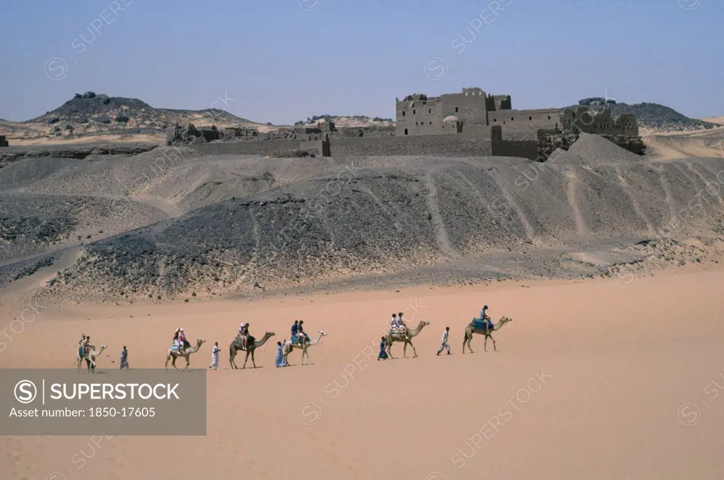 Egypt, Nile Valley, Aswan, Monastery Of St Simeon.  Deserted Monastery On The West Bank Of The River Nile Built In The 7Th Centuary Ad.  Passing Tourist Camel Train In Foreground.